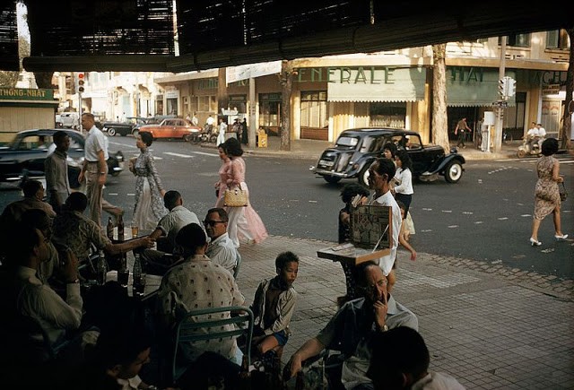  Sài Gòn những năm 1960 trong bộ ảnh của nhiếp ảnh gia Wilbur E. Garrett hiện lên thanh bình và mộc mạc. Trong ảnh là nhiều người dân Sài Gòn ngồi uống nước, trò chuyện tại một quán nước năm 1961.