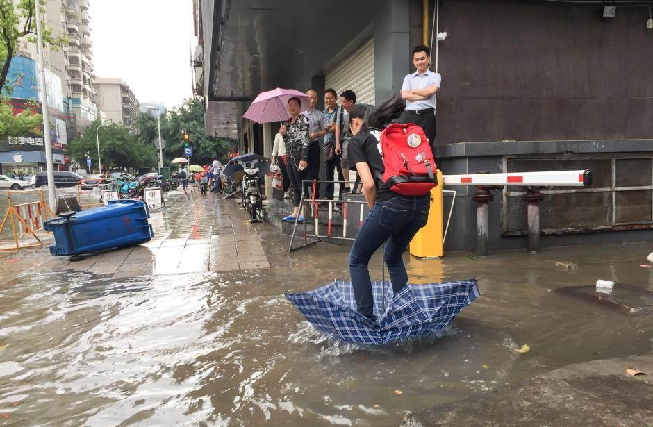 Tại thành phố Phúc Châu, Trung Quốc, mưa lớn kéo dài khiến cho một số tuyến phố ngập lụt nặng, giữa thành phố hình thành những con "sông" nhỏ. Tuy nhiên điều này có vẻ khá vui vẻ với người dân khi họ sáng tạo ra vô số cách "vượt sông" bá đạo. Trong ảnh, cô gái trẻ dùng ô làm "thuyền" để cập bến.