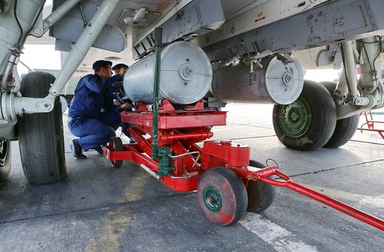 Trong ảnh, các kĩ thuật viên không quân Nga đang lắp quả bom lên giá treo bụng  máy bay cường kích Su-24 tham gia cuộc tập trận Center-2015 diễn ra từ ngày 25/5 với sự tham gia của 12.000 quân cùng 250 máy bay các loại.