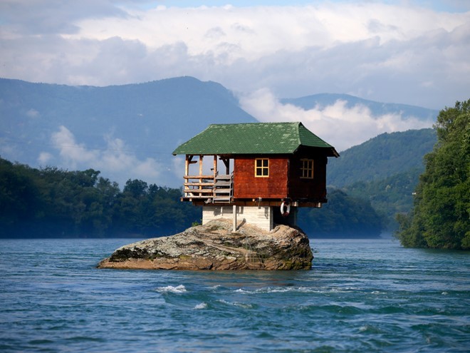 Tọa lạc gần thị trấn Bajina Basta tại Serbia, một  ngôi nhà độc đáo, được xây vào năm 1968, đứng vững gần 50 năm trên đỉnh của một tảng đá nằm ở giữa sông Drina. Ảnh: Reuters.