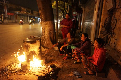 Cận kề Tết Nguyên đán, mọi người bận rộn sắm sửa, dọn dẹp… chuẩn bị cho một cái Tết ấm áp. Nấu bánh chưng chung là lúc xum họp gia đình đông đủ nhất, chính vì vậy nhiều gia đình ở Hà Nội lại cùng nhau cất nồi bánh chưng trên vỉa hè ngay trước nhà dù không có nhiều không gian. Trong ảnh, sáu chị em nhà bà Hương đang trông nồi bánh chưng tại vỉa hè phố Lê Duẩn