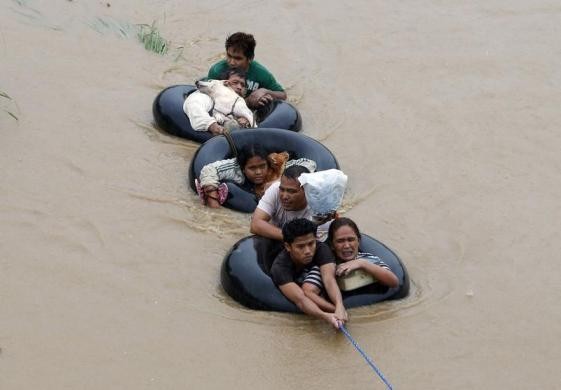 Cơn bão nhiệt đới "Agaton" đổ bộ vào miền nam Philippines cuối tuần trước gây ra mưa lớn, lũ lụt trên diện làm ít nhất 40 người thiệt mạng. Hơn 580.000 người khác đã buộc phải sơ tán, tránh sạt lở đất và lũ lụt sau bão. Trong ảnh, người dân vùng lũ ở đảo Mindanao, miền nam Philippines phải bám vào lốp xe để chạy lụt.