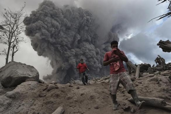 Người dân làng Gamber, huyện Karo, tỉnh Bắc Sumatra của Indonesia chạy trốn tro bụi của núi lửa Sinabung đang ở giai đoạn phun trào dữ dội ngày 21/1.