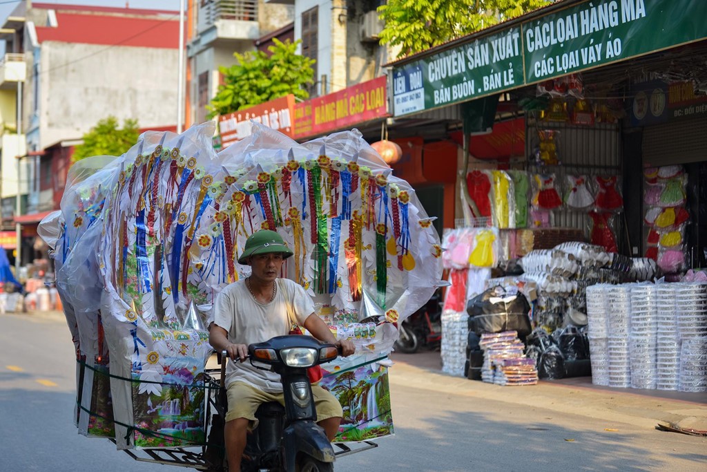 Những ngày trước rằm tháng 7, bầu không khí lao động tất bật bao trùm xã Song Hồ (Bắc Ninh). Các hộ gia đình khẩn trương hoàn thiện các sản phẩm vàng mã theo đặt hàng của khách và ngược xuôi vận chuyển.