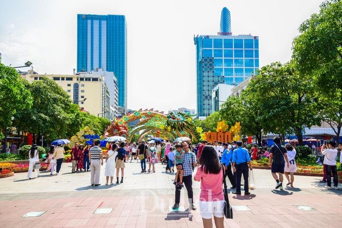 Hàng ngàn người dân và du khách du xuân ghé đến đường hoa xuân Nguyễn Huệ tham quan và chụp ảnh lưu niệm.