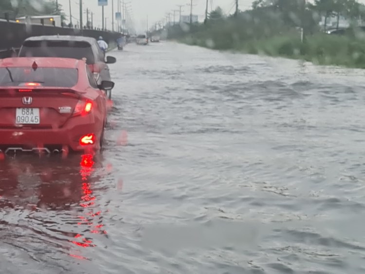 Chiều 12/6, sau cơn  mưa kéo dài hơn 2 tiếng, đoạn quốc lộ 1 qua  khu công nghiệp Hòa Phú, huyện Long Hồ, tỉnh Vĩnh Long biến thành sông. Ảnh: An Quý