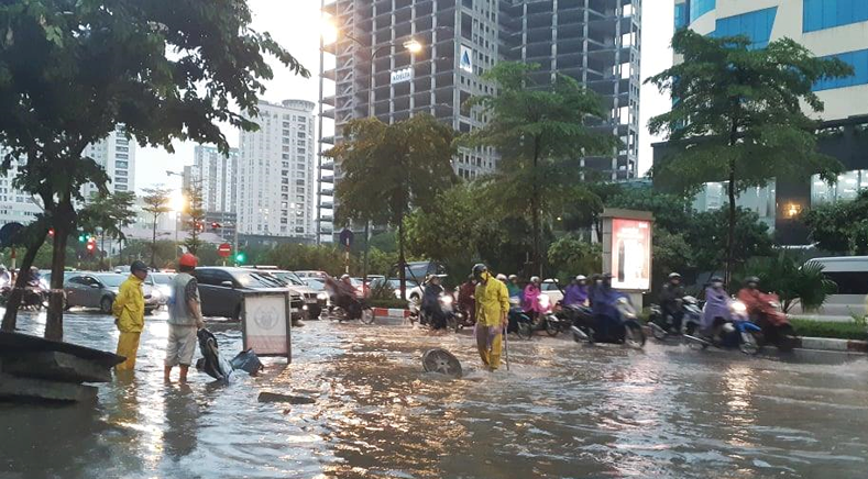 Tại phố Phạm Văn Bạch (quận Cầu Giấy), chỉ cần mưa nhỏ, nước mưa sẽ dâng cao ngập quá nửa bánh xe máy khiến nhiều phương tiện di chuyển khó khăn.