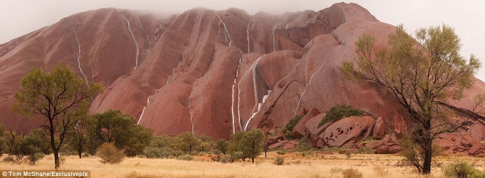 Những dòng nước trắng xóa bao phủ núi Uluru đá ở Alice Springs, Australia, sau một số trận mưa.