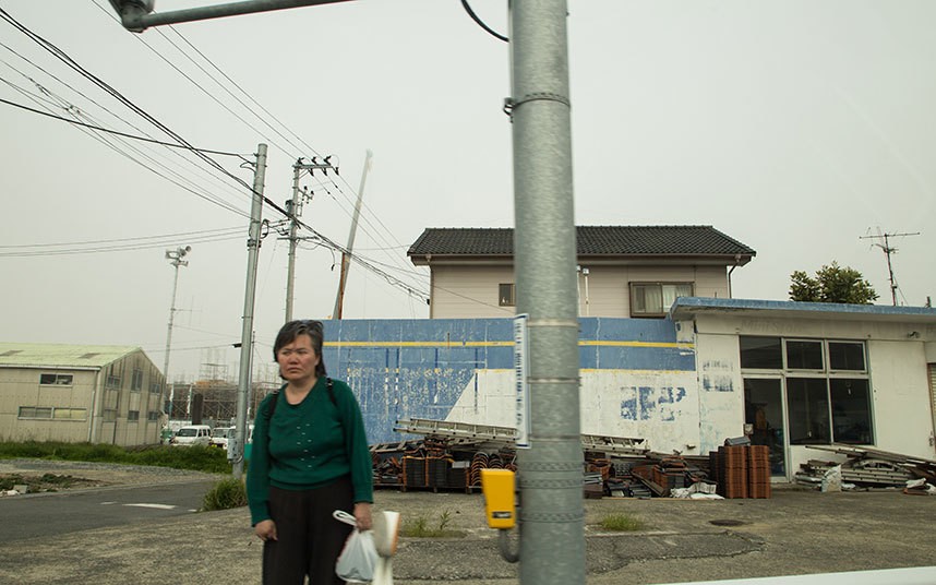 Một người dân thường đứng trên đường ranh giới với "vùng cấm" ở thị trấn Fukushima.