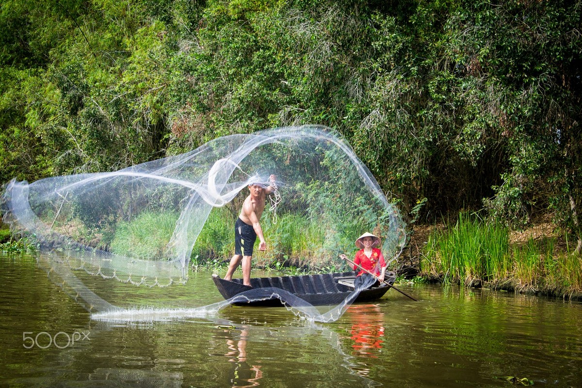 Người dân chài thả lưới đánh cá ở Đồng Tháp, miền Nam Việt Nam. Ảnh: Raymond Low - 500px.com.