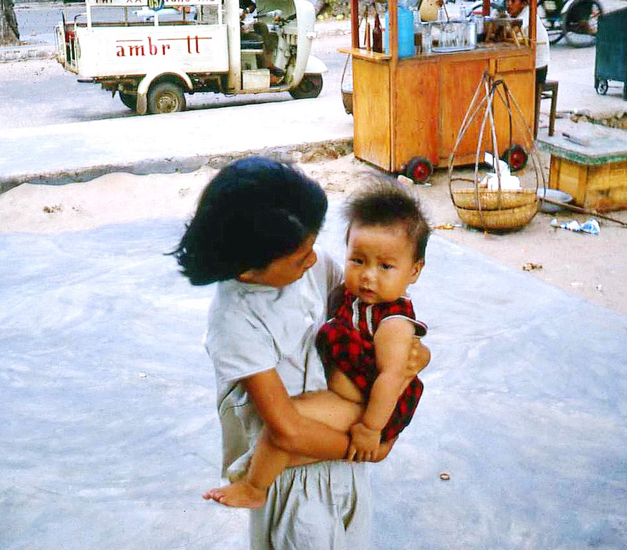 Bé gái bế em nhỏ trên vỉa hè  Vũng Tàu năm 1967. Ảnh: Bruce Tremellen.