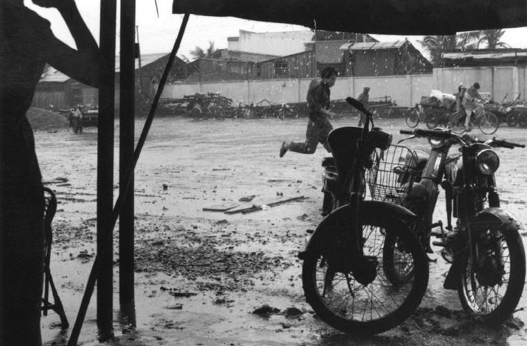 Cơn mưa bất chợt khiến người đi đường nháo nhác,  Sài Gòn năm 1993. Ảnh: Ferdinando Scianna/ Magnumphotos.com.