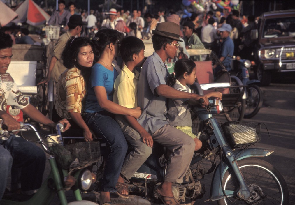 Một gia đình 5 người di chuyển bằng xe máy ở Phnom Penh năm 1994. Cũng như ở Việt Nam, xe máy là phương tiện di chuyển chính của người dân  Campuchia thập niên 1990. Ảnh: Hiroji Kubota/ Magnum Photos.