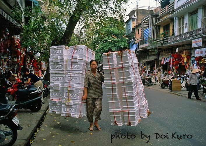 Người  phụ nữ Việt Nam gánh thùng xốp trên phố Hàng Mã, Hà Nội năm 1999.Ảnh: Doi Kuro.