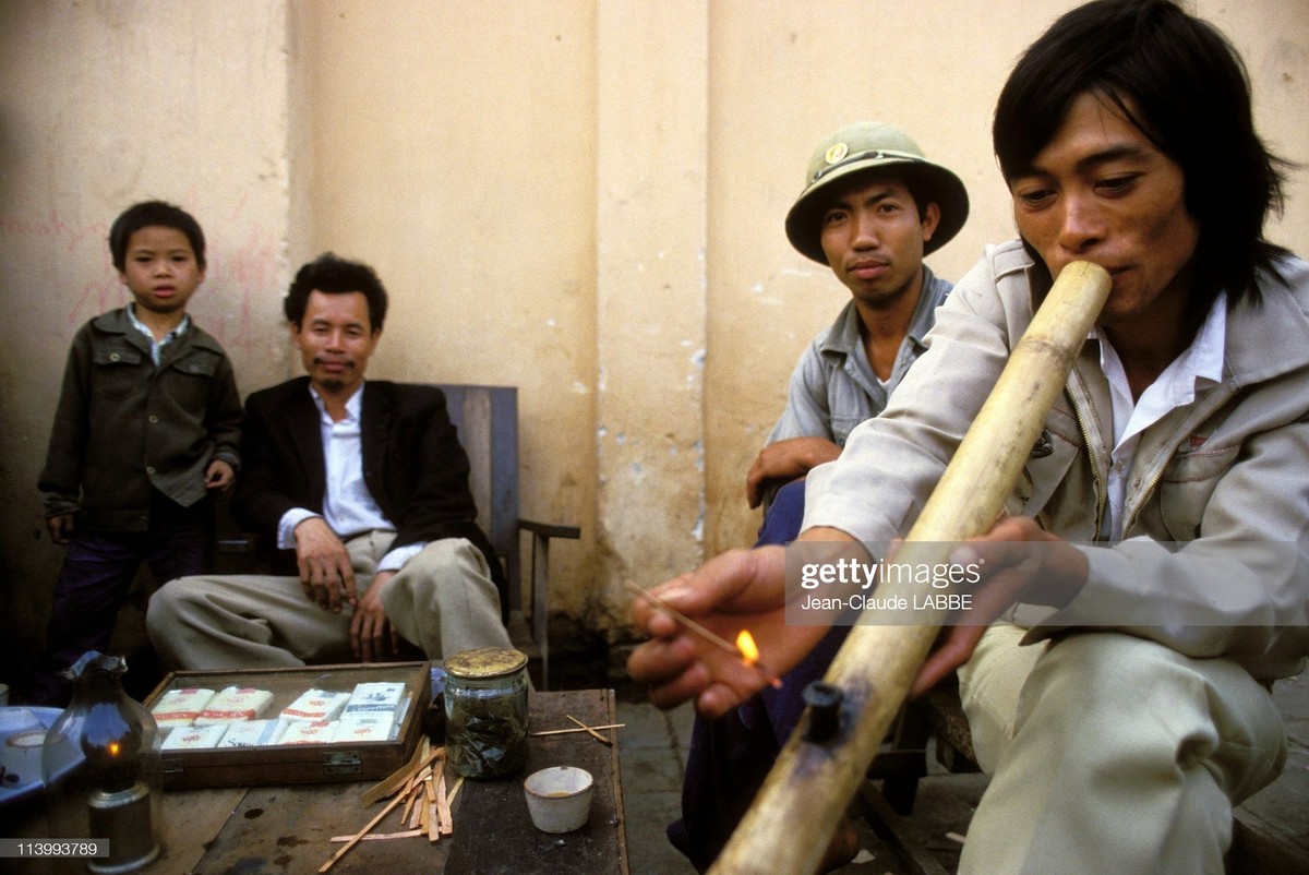 Thanh niên hút thuốc lào tại một quán trà đá vỉa hè,  Hà Nội năm 1994. Ảnh: Jean-Claude Labbe/ Getty Images.