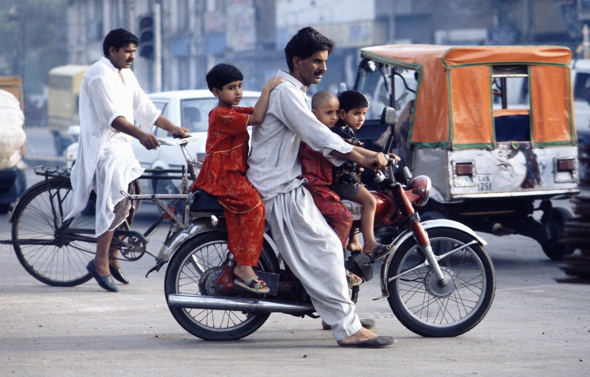 Người đàn ông chở ba đứa trẻ trên xe máy ở Lahore, thủ phủ tỉnh Punjab, thành phố lớn thứ hai  Pakistan, năm 1995.