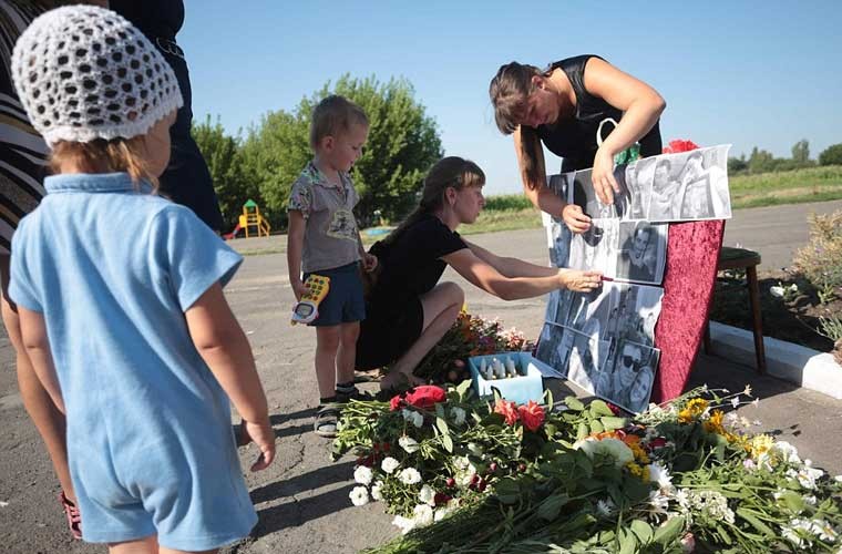 Hai năm sau  thảm kịch MH17, người dân Ukraine và thân quyến của 298 nạn nhân xấu số đã tổ chức buổi tưởng niệm dành cho những nạn nhân. Ảnh: Dân làng Petropavlivka, tỉnh Donetsk, miền đông Ukraine đặt những tấm ảnh của các nạn nhân tại khu tưởng niệm tạm thời.