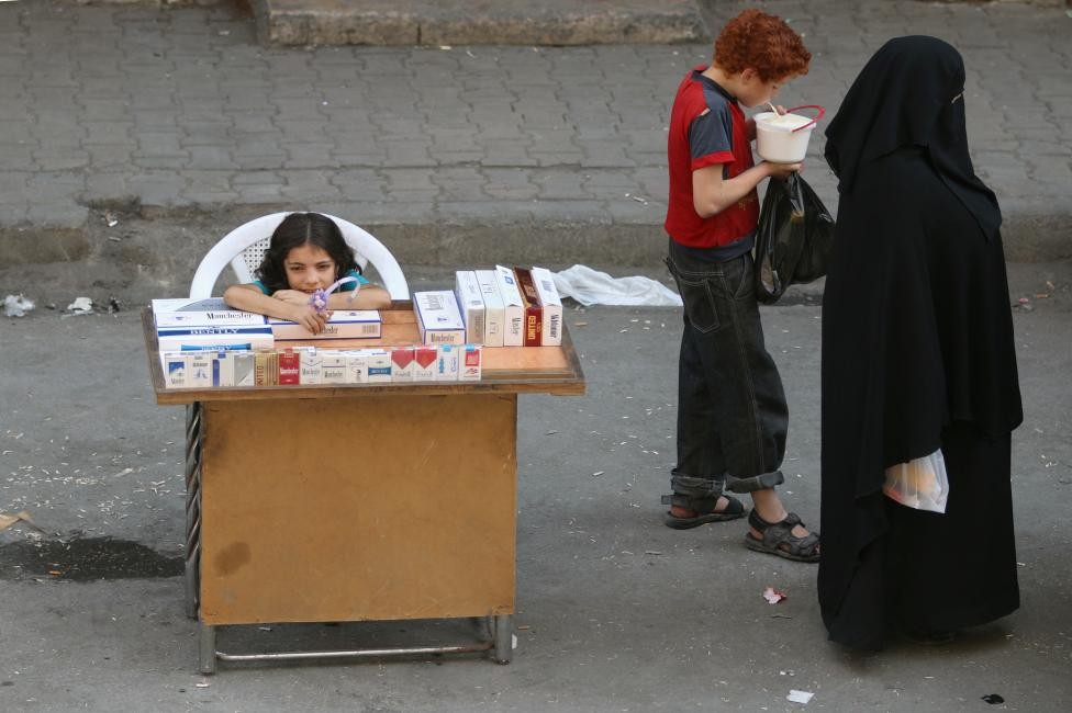  Chảo lửa Aleppo là nơi diễn ra các cuộc giao tranh ác liệt kéo dài giữa quân đội chính phủ Syria, phe nổi dậy và cả phiến quân IS. Ảnh: Bé trai ăn sữa chua gần một bé gái đang bán thuốc lá ở khu dân cư al-Shaar ở Aleppo.