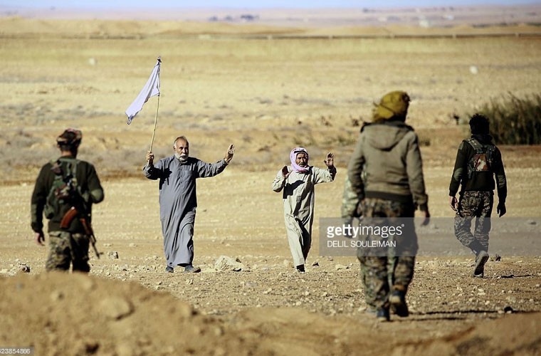 Hai dân thương giơ cao cờ trắng khi thấy các thành viên Lực lượng Dân chủ Syria (SDF) tiến công vào ngôi làng Tall as Samn gần chiến trường đánh  phiến quân IS vào hôm 17/11. Ảnh GT