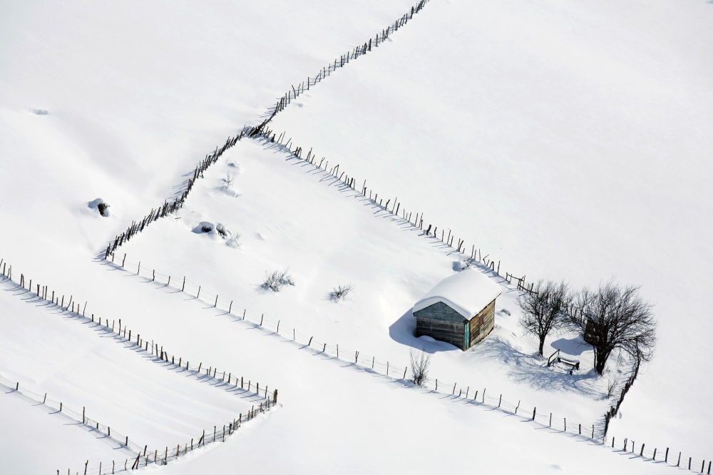 Một mái nhà tranh giữa vùng tuyết trắng xóa ở dãy núi Talysh, Iran. Vào mỗi  mùa đông ở Iran với tuyết phủ trắng xóa, những người dân làng sống ở dãy núi Talysh, cách Thủ đô Tehran chừng 430 km theo hướng đông nam, thường rời nhà họ để tìm nơi ấm áp hơn. Khi mùa xuân về, họ quay trở lại làng để trồng rau, chăn nuôi gia súc hay đón tiếp du khách. Ảnh Sputnik