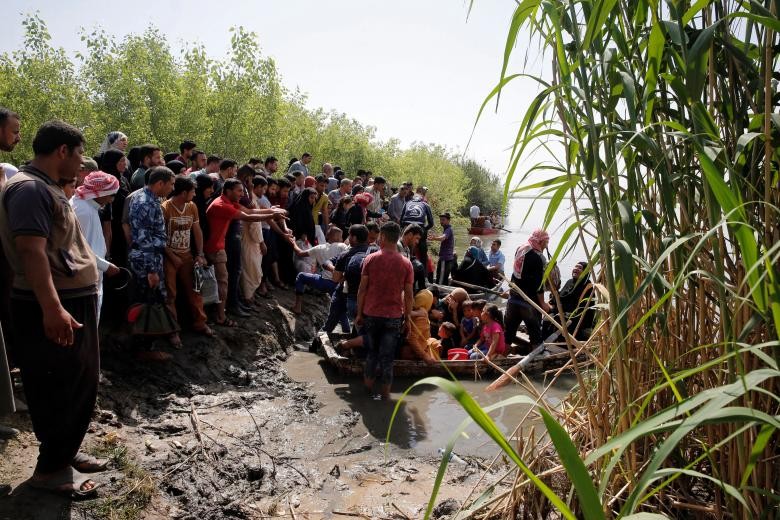 Hàng trăm cư dân  Mosul ồ ạt vượt sông Tigris bằng những chiếc thuyền gỗ nhỏ sau khi tất cả các cây cầu nối thành phố này đều bị ngập do mưa lũ.