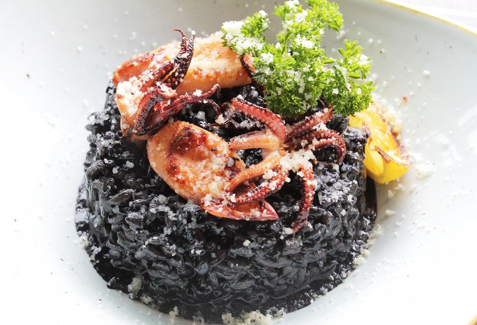 1. Crni Rizot - Black Risotto: Các tín đồ hải sản không thể bỏ qua món ăn này khi đến  Croatia. Món ăn đặc sắc của Croatia này có nguồn gốc từ vùng duyên hải của đất nước này. Món này có nguyên liệu từ bạch tuộc, khoai tây, rượu vang, gạo. Màu đen đặc trưng của món ăn là những miếng phô mai cừu béo ngậy. Sau cùng món ăn được rắc phô mai parmesan vụn lên trên cùng. Ảnh: Viettravel.