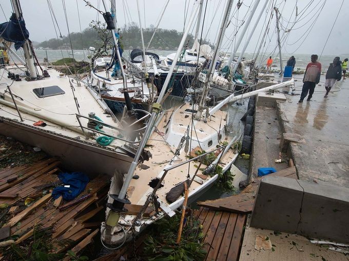 Người dân địa phương quan sát những chiếc thuyền bị phá hủy ở thủ đô Port Vila của nước Cộng hòa Vanuatu ngày 14/3/2015. Theo thông tin từ một quan chức cứu trợ thì đây là  cơn bão mạnh nhất từng tàn phá đảo quốc này và là một trong những thảm họa thiên nhiên tồi tệ nhất trong khu vực Thái Bình Dương.