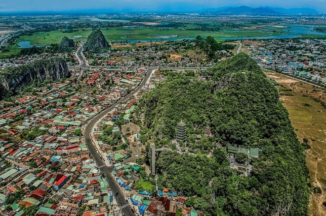 Cách trung tâm Đà Nẵng khoảng gần 10 km về phía đông nam, quần thể danh thắng  Ngũ Hành Sơn nổi tiếng gồm 6 ngọn núi. Trong ảnh, tính từ phải qua, ngược chiều kim đồng hồ lần lượt là Thủy Sơn, Thổ Sơn, Kim Sơn, Hỏa Sơn - gồm Dương Hỏa Sơn cao hơn Âm Hỏa Sơn, là 2 ngọn tách rời nhau nhưng có chung một chân đá, và Mộc Sơn.