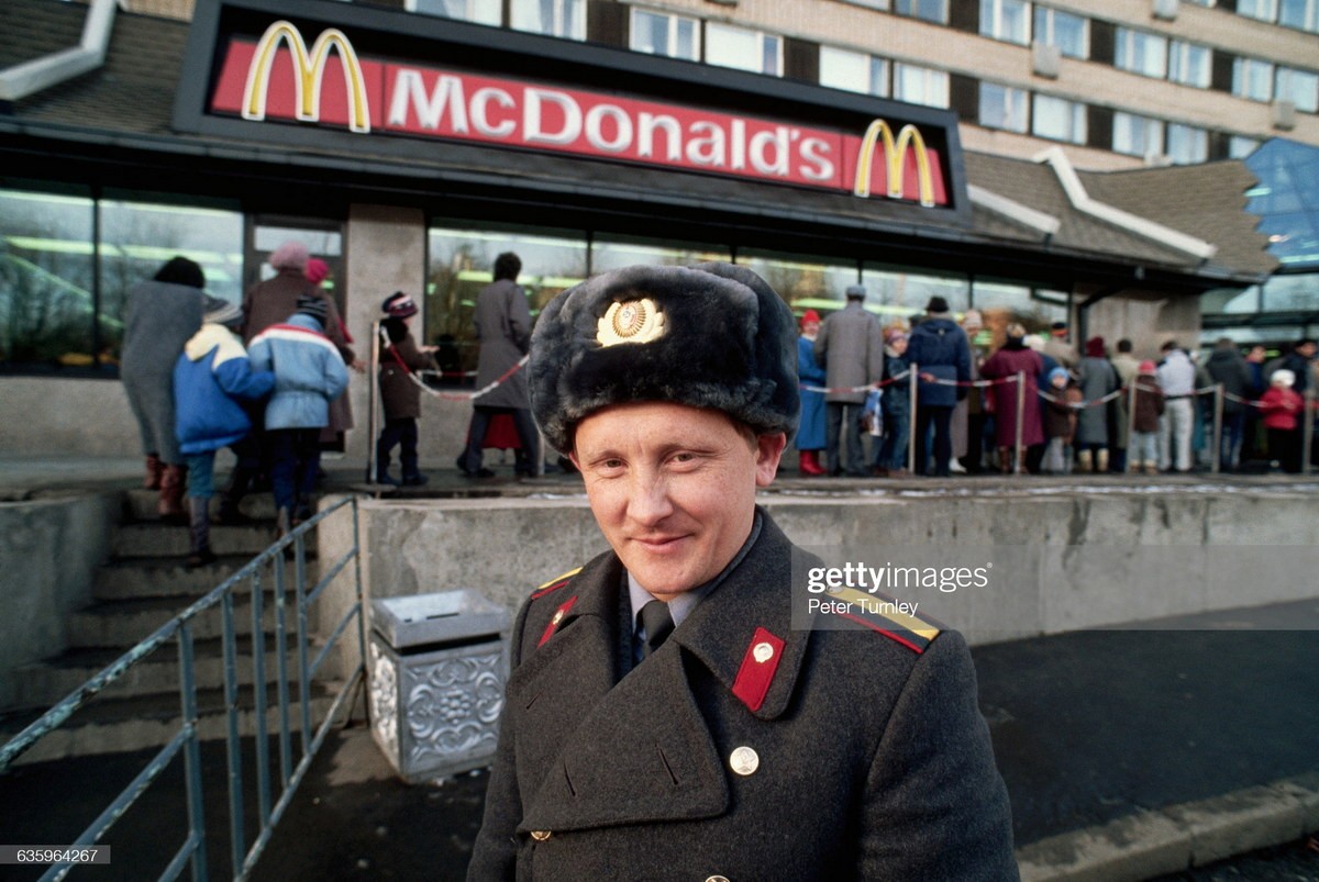 Một cảnh sát đứng bên hàng người chờ vào cửa hàng McDonald's mới mở trên phố Gorky ở Moscow,  Nga năm 1990, một năm trước khi Liên Xô sụp đổ. Ảnh: Peter Turnley/ Getty Images.