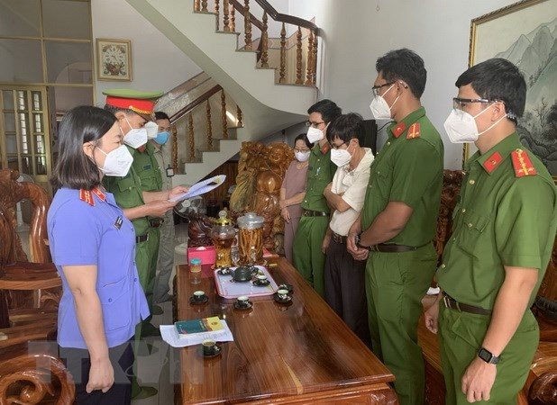 Đại diện Cơ quan Cảnh sát điều tra đọc lệnh khởi tố, bắt tạm giam ông Đoàn Thế Nam (áo trắng, giữa, bên phải), nguyên Hiệu trưởng Trường Cao đẳng Nghề Bình Phước. (Ảnh: TTXVN) truong-cao-dang-nghe-binh-phuoc(1).jpg