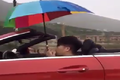 Thanh niên lái xe mui trần cầm ô che mưa
