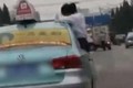 Video: Thiếu nữ ngồi trên cửa xe taxi để làm... bài tập