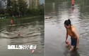 Video: Cô gái bơi qua con đường ngập nước vì sợ đi làm muộn