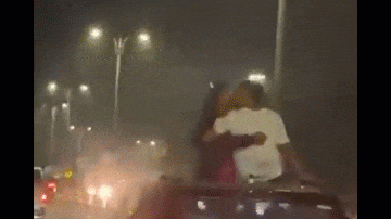 Video: Ngồi trên nóc ô tô đang chạy, cặp đôi hôn nhau say đắm
