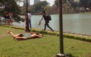 Hai du khách Tây ăn mặc phản cảm nằm trên bãi cỏ ở Hồ Gươm