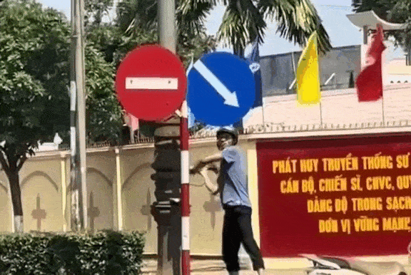 Người đàn ông dùng búa đập phá biển báo trên đường