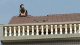 Cãi nhau với chồng, vợ leo lên mái nhà dỡ ngói ném xuống