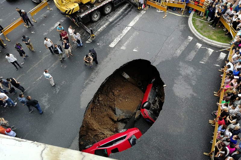 A construction vehicle lies where it was swallowed by a sinkhole on Saint-Catherine Street in downtown Montreal