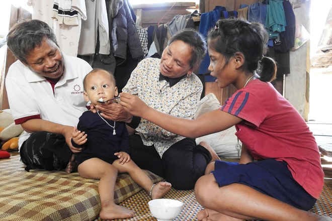 Chị Căn Linh, anh Côn Linh và bé Hồ Thị Miếc chăm sóc cho thành viên nhỏ nhất trong gia đình.