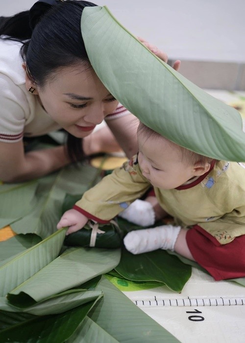 Phuong Oanh khoe hai con dien ao dai ngoi xem goi banh chung-Hinh-4