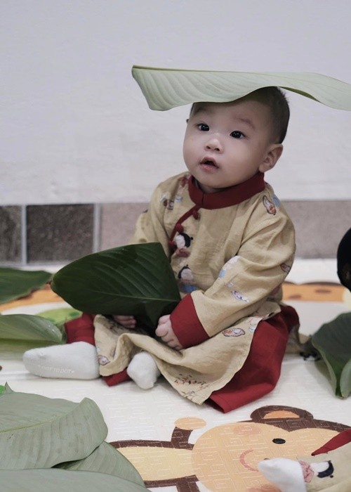 Phuong Oanh khoe hai con dien ao dai ngoi xem goi banh chung-Hinh-7