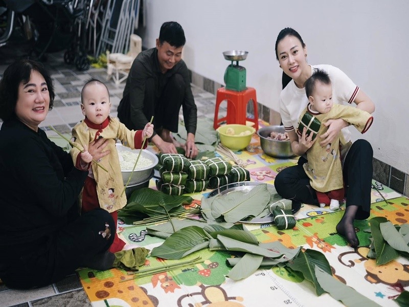 Phuong Oanh khoe hai con dien ao dai ngoi xem goi banh chung