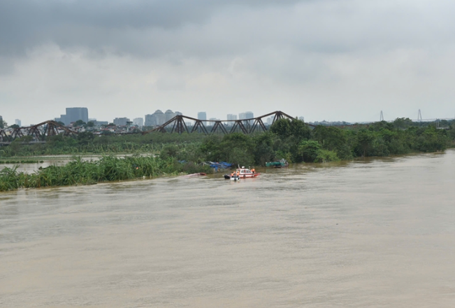 Ha Noi: Giai cuu 3 nguoi tren tau cat bi lat o song Hong