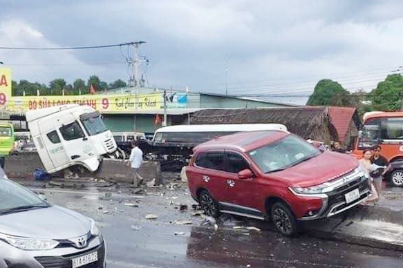 Cuon thep tren dau keo container roi xuong duong, o to lao len dai phan cach