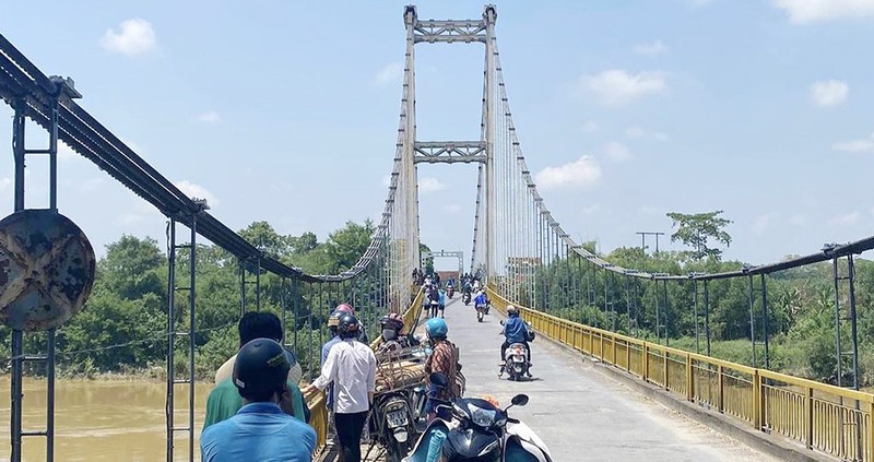 Nam sinh bo lai cap sach tren cau nghi nhay song Lam tu tu