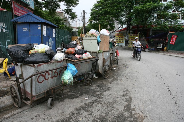 Hàng loạt xe thu gom rác không được che bạt nằm ngay đầu ngã ba phố Hoàng Ngân – Lê Văn Lương.