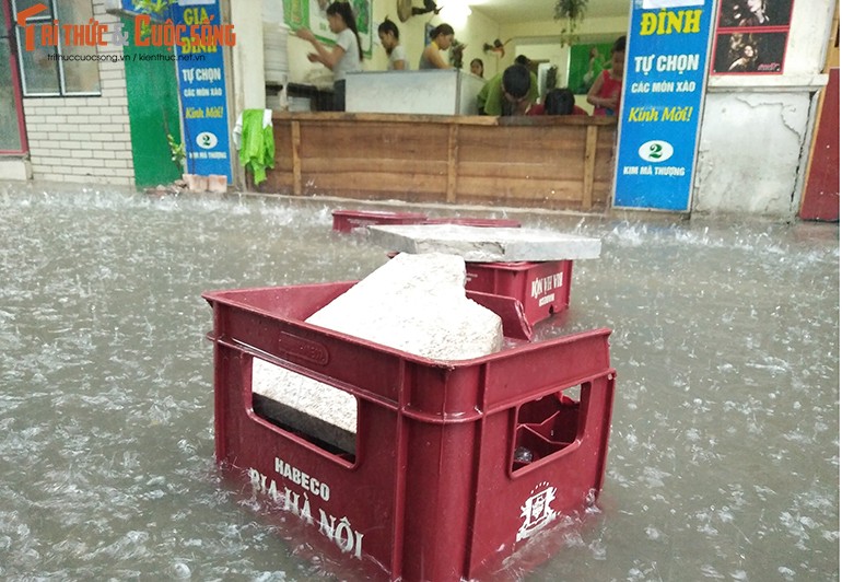 Anh: Quan xa dong cua, nuoc mua chay ngap nha dan o Ha Noi